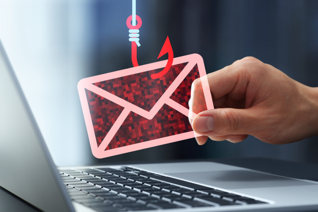 Hand holding a phishing email envelope with a hook representing business email compromise attacks targeting law firms