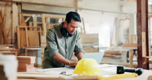 Construction contractor reviewing documents on a laptop at a job site workbench representing email security risks for construction companies